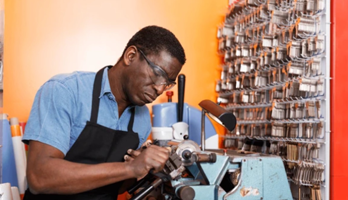 Locksmith Cary cutting a key with a machine in a workshop.