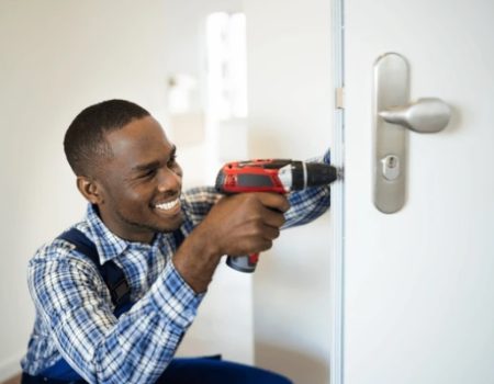 Skilled locksmith using a power drill for precision lock installation, showcasing reliable and efficient door security solutions
