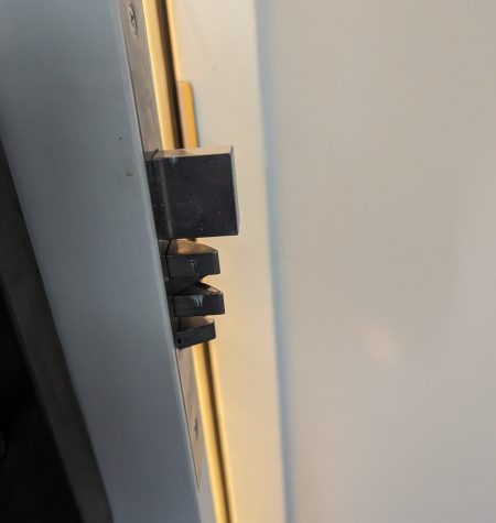 Monitor hinge mechanism close-up against a wall.